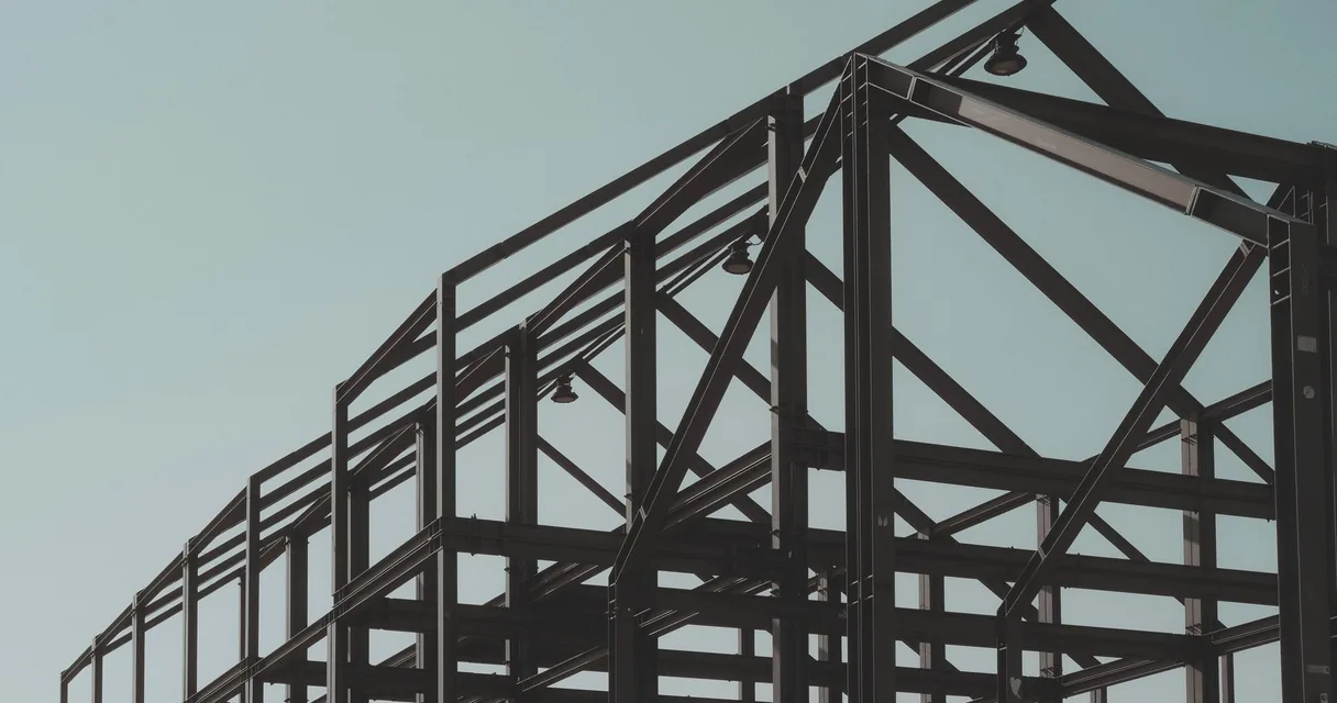 Estrutura metálica de uma construção contra o céu claro, ilustrando casas híbridas
